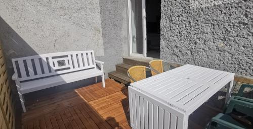 a porch with two chairs and a bench and a window at Eklektyczny i przestronny apartament z tarasem w pobliżu jeziora i Gór Sowich in Bielawa