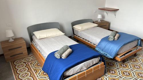 2 Einzelbetten in einem Zimmer mit blauer Bettwäsche in der Unterkunft PiazzaCavourApartment17 in Ancona