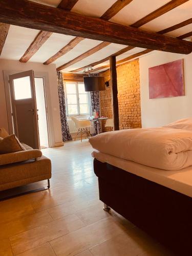 a bedroom with a bed and a living room at Klosterhof Weingut BoudierKoeller in Stetten