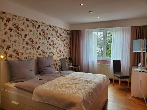 a bedroom with a bed with a floral wallpaper at Privatpension Waldbröl in Waldbröl