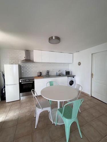 une cuisine avec une table et des chaises dans une cuisine dans l'établissement La Perle Marine - Magnifique vue sur la mer, à Saint-Brieuc