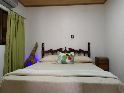 a bedroom with a bed with a green curtain at Casa Victoria in Puntarenas
