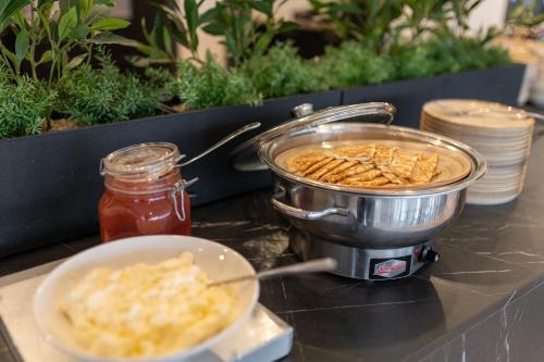a counter with a pot of food and a bowl of food at Solna Park & Hotel in Solna