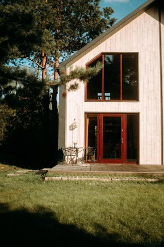 a house with a red door and a table in front at Maciejówka Borki 33 in Borki