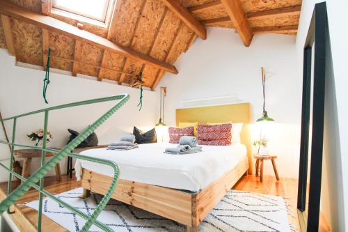 een slaapkamer met een bed in een kamer met houten plafonds bij Macário Cosy Loft in Porto