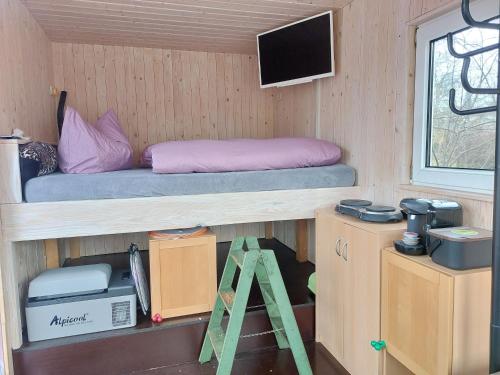 a room with a bed and a tv and a desk at Bauwagen Gnubbel am Jahnteich in Weißwasser