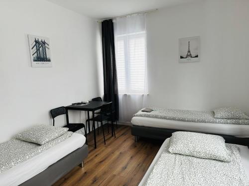 a room with two beds and a desk in it at Pokoje Gościnne Strumykowa in Lublin