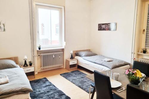 1 dormitorio con 2 camas, mesa y ventana en 3-room Apartment in Offenbach, en Bieber