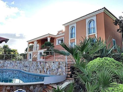 une maison avec une piscine devant une maison dans l'établissement VILLA VUE MER, à Pietrosella