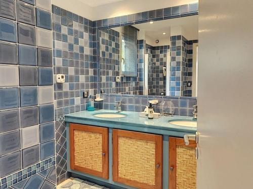 een badkamer met twee wastafels en een spiegel bij VILLA VUE MER in Pietrosella