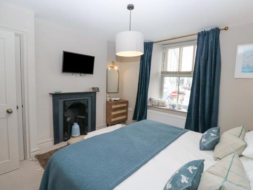 a bedroom with a bed with a fireplace and a tv at 8 Charles Street in Dartmouth
