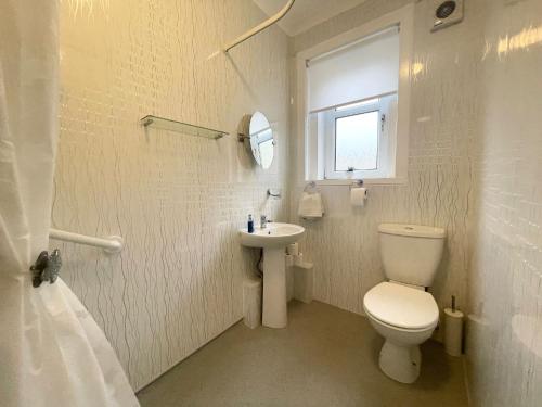 La salle de bains blanche est pourvue de toilettes et d'un lavabo. dans l'établissement Stunning 2-Bed Apartment in Greenock - Sleeps 6, à Greenock