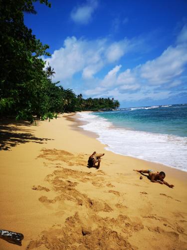 a couple of people laying on a beach at Praia Piscina in Santa Joaquina