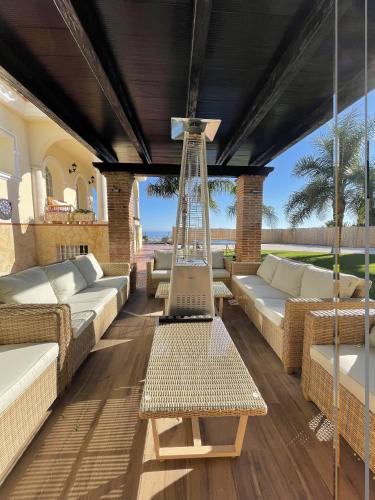 an outdoor patio with couches and a hammock at Malagasuite Villa Moriana in Mijas