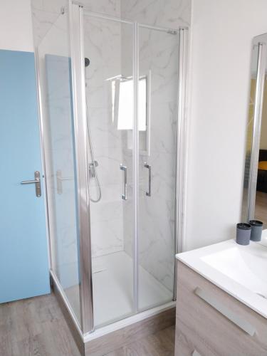 une douche avec une porte vitrée dans une salle de bain dans l'établissement Appartement refait à neuf., à Mers-les-Bains