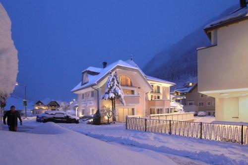 een huis met sneeuw erop in een sneeuwtuin bij Grütter Luxury Apartments in Ischgl