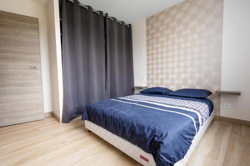 a bedroom with a bed with blue sheets and a window at Maison au calme * parking privé * wifi in Villemandeur