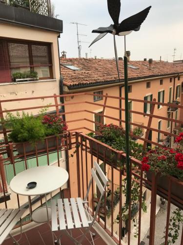 a balcony with a table and a bird on a pole at Fleur Blanche in Verona