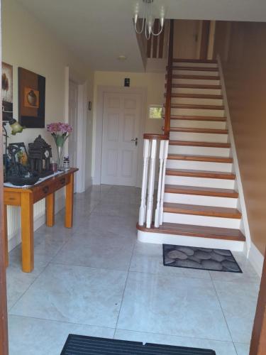 a staircase in a living room with a table and a stair case at Ard na Coille in Tralee