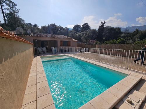 une piscine en face d'une clôture dans l'établissement TAGLIO ROSSO-piscine privée chauffée- proche piscines naturelles du Cavu- Pinarello, à Capo