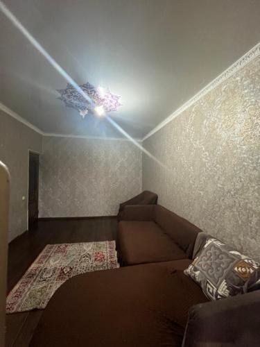 un soggiorno con divano e soffitto di Квартира a Shymkent