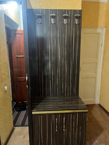 a black refrigerator in a room with a door at Квартира in Shymkent