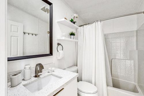 a white bathroom with a sink and a shower at Lime in the Coconut in Marathon
