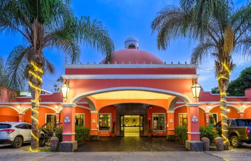 un edificio de naranjos con palmeras delante de él en Hacienda San Juan Resort en Ica