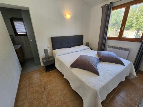 une chambre avec deux lits avec des oreillers dessus dans l'établissement TAGLIO ROSSO-piscine privée chauffée- proche piscines naturelles du Cavu- Pinarello, à Capo