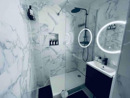 a white bathroom with a shower and a sink at Superbe duplex cosy in Reims