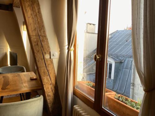 a window in a room with a view of a house at Central Duplex with Panoramic Views over Paris in Paris