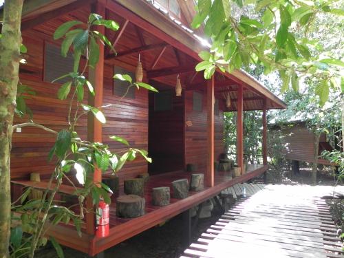 a wooden cabin with pots on the porch of it at Borneo Natural Sukau Bilit Resort in Bilit