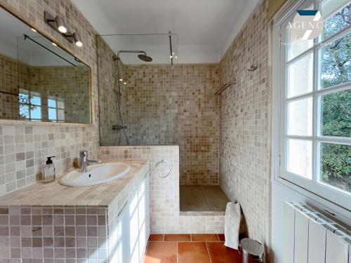 une salle de bain avec un lavabo et un miroir dans l'établissement La Louarde, aux Issambres