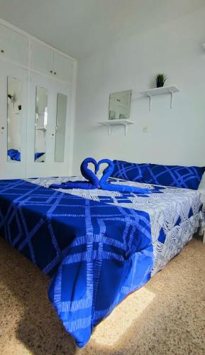a blue comforter on a bed in a bedroom at Sunny Room in Habitat in Maspalomas