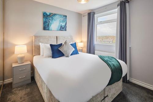 een slaapkamer met een groot wit bed met blauwe kussens bij Host & Stay - Bartlemere House in Barnard Castle