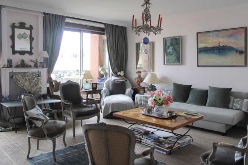 - un salon avec un canapé, une table et des chaises dans l'établissement Comfortable flat with view on the Eiffel Tower, à Boulogne-Billancourt