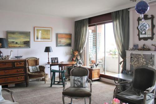 - un salon avec des chaises, une table et une fenêtre dans l'établissement Comfortable flat with view on the Eiffel Tower, à Boulogne-Billancourt