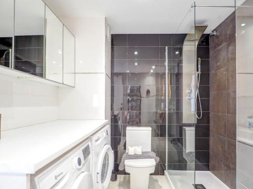 y baño blanco con aseo y ducha. en Marina Duplex by Hello Homes Sitges en Sitges