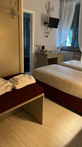 a hotel room with two beds and a desk at B&B Villa degli Aceri in Carcare