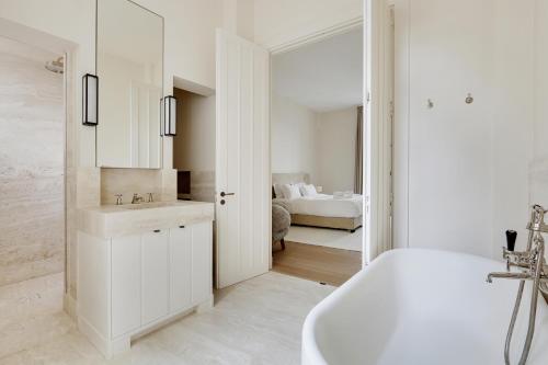 een witte badkamer met een wastafel en een bad bij Pick A Flat's Apartment in Invalides - Rue de Constantine in Parijs