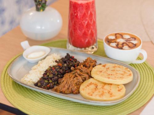 a plate of food with rice beans and meat at Valle de Santiago Hotel Boutique in San Cristóbal