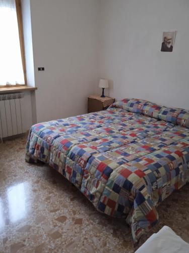 una camera da letto con un letto con un piumone colorato di Casa Serena a Scanno