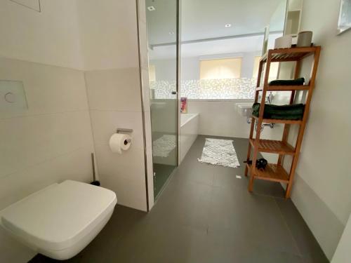 a bathroom with a toilet and a glass shower at Cityloft Gold - Zentrum / 105qm / inkl. Parkplatz / Netflix in Leipzig
