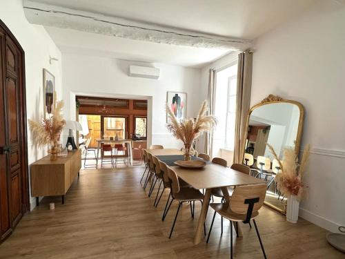 une salle à manger avec une table, des chaises et un miroir dans l'établissement Grande Maison familiale Leucate Village, à Leucate
