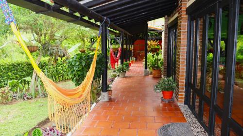 een veranda met een hangmat aan de zijkant van een huis bij Finca PANACA Jagüey 12 VIP Group - Villas for Rent in in Quimbaya