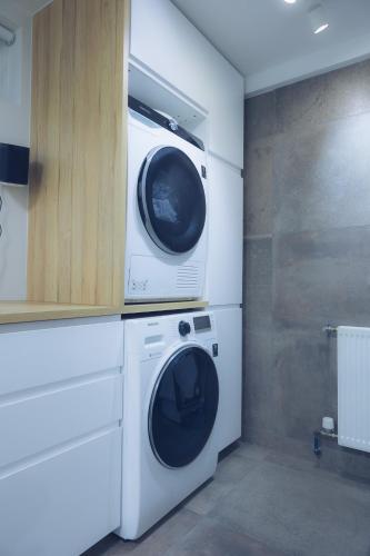 a washer and dryer in a white laundry room at Smart Luxury - Private Gym, Hot Tub & Sauna in Keflavík