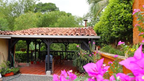 a patio with a tiled roof in a garden at Finca PANACA Jagüey 12 VIP Group - Villas for Rent in in Quimbaya