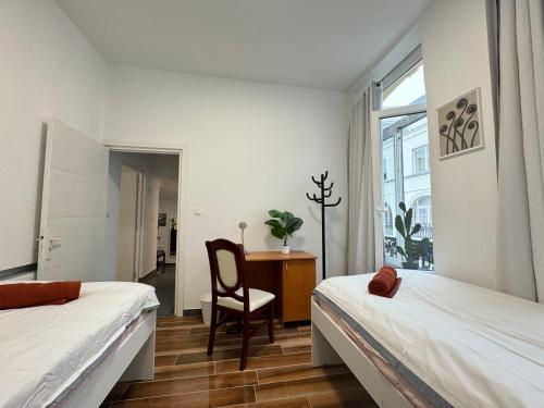 1 dormitorio con 2 camas, silla y escritorio en Sweet Dream House, en Bruselas