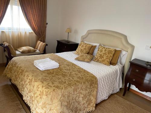 a hotel room with a bed and a chair at Casa dos Pexins in Nazaré
