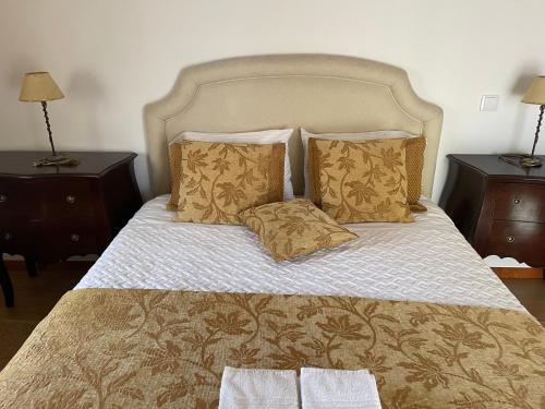 een slaapkamer met een groot bed met 2 nachtkastjes bij Casa dos Pexins in Nazaré
